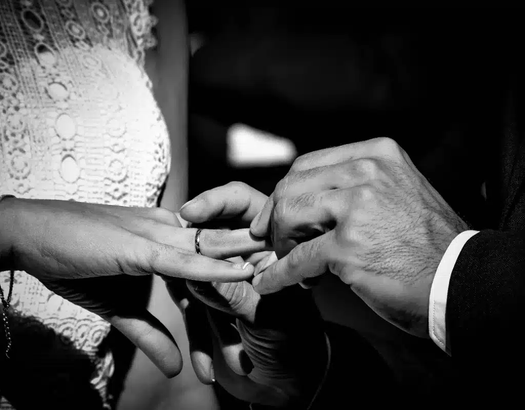 Bodas en Madrid Centro: 8 Hoteles de Ensueño (y su Secreto) 💒 2 Primer plano en blanco y negro de unos novios intercambiando los anillos durante su boda urbana en un hotel del centro de Madrid.